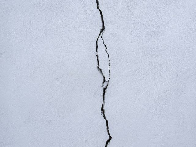 A crack running down a stucco wall