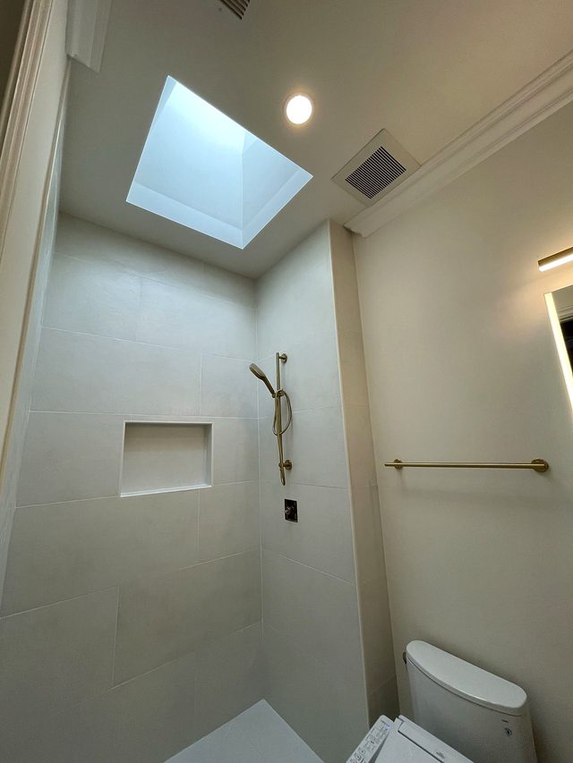 Remodeled walk-in shower under a skylight
